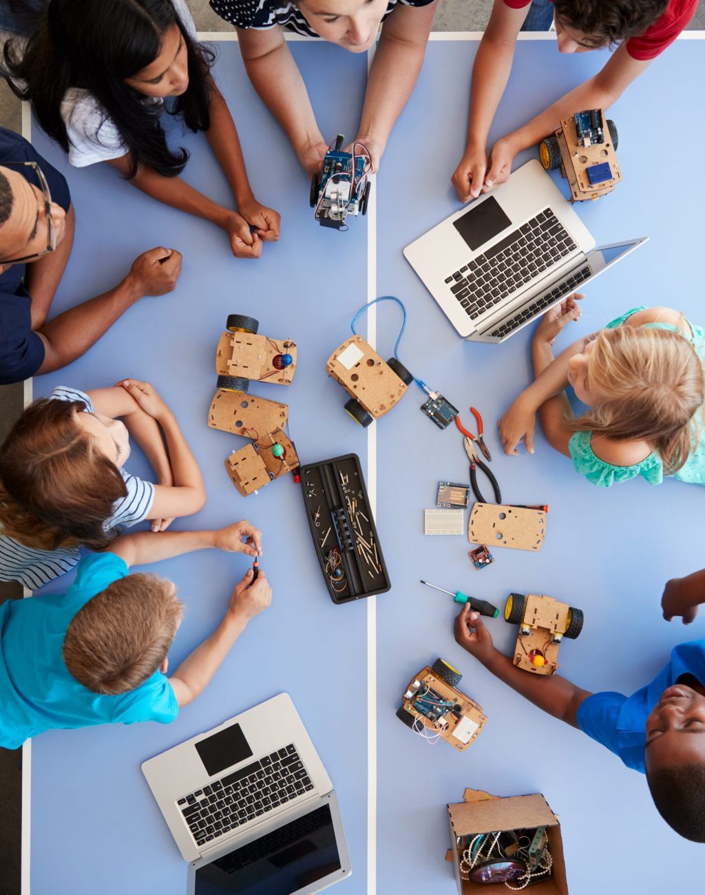Overhead View Of Students In After School Computer Coding Class Learning To Program Robot Vehicle Overhead View Of Students In After School Computer Coding Class Learning To Program Robot Vehicle