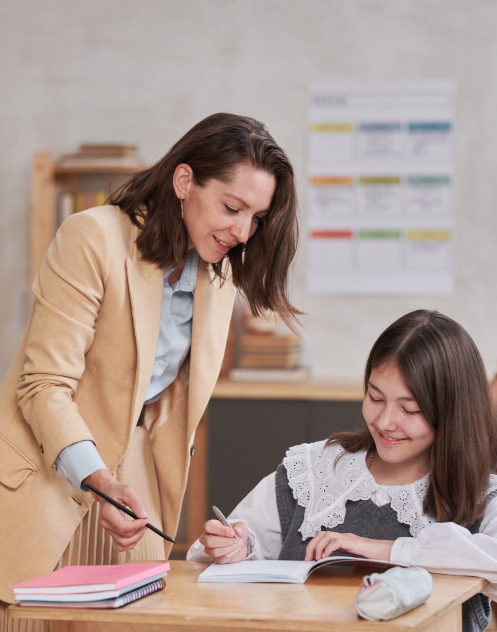 Teacher Helping Kids in School Portrait of smiling female teacher helping children during class in school, copy space